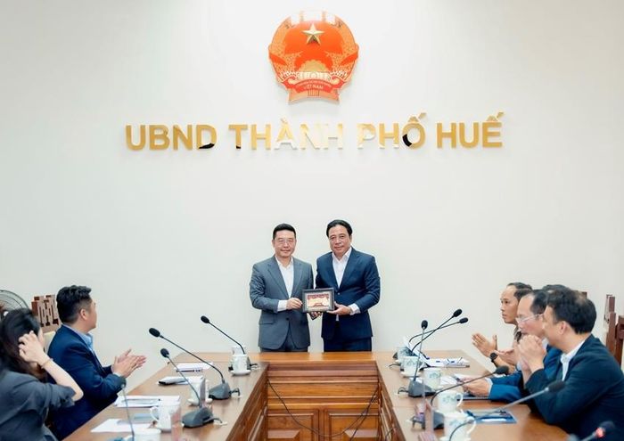 Chủ tịch UBND thành phố Nguyễn Khắc Toàn (bên phải) trao quà lưu niệm đến lãnh đạo đoàn