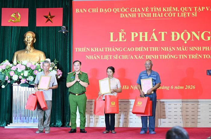 Thứ trưởng Bộ Công an Nguyễn Văn Long trao quà cho đại diện thân nhân các liệt sĩ vừa được xác định danh tính.