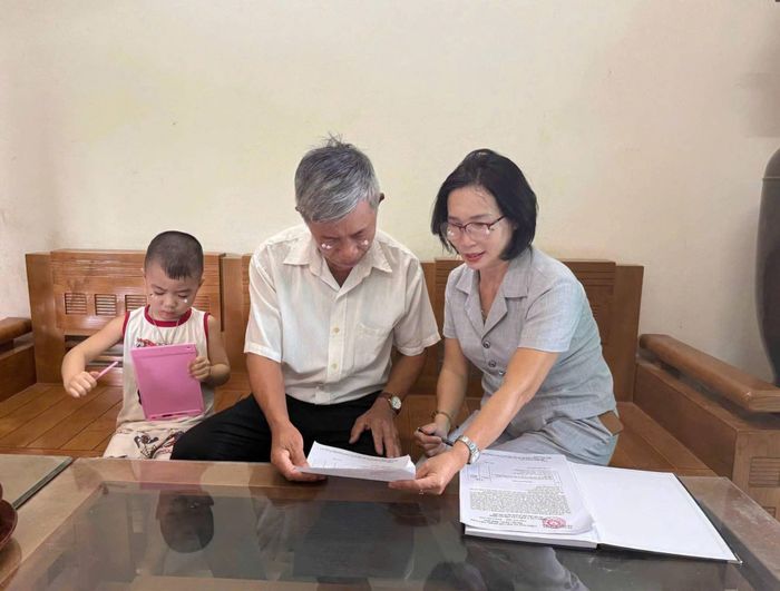 Cán bộ tổ dân phố hướng dẫn người dân về việc lấy ý kiến sáp nhập tổ dân phố