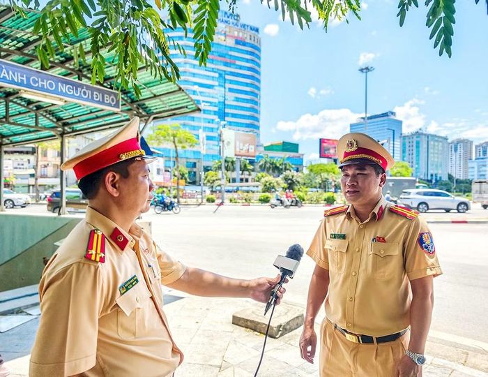 Trung tá Nguyễn Ngọc Tiến tác nghiệp, phỏng vấn đồng nghiệp để xây dựng clip tuyên truyền về an toàn giao thông.