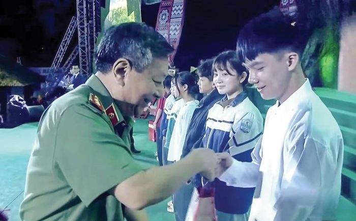 Trung tướng Đỗ Triệu Phong, Cục trưởng Cục Truyền thông CAND tặng quà các gia đình có hoàn cảnh khó khăn tại chương trình giao lưu nghệ thuật “Vì bình yên bản làng”.