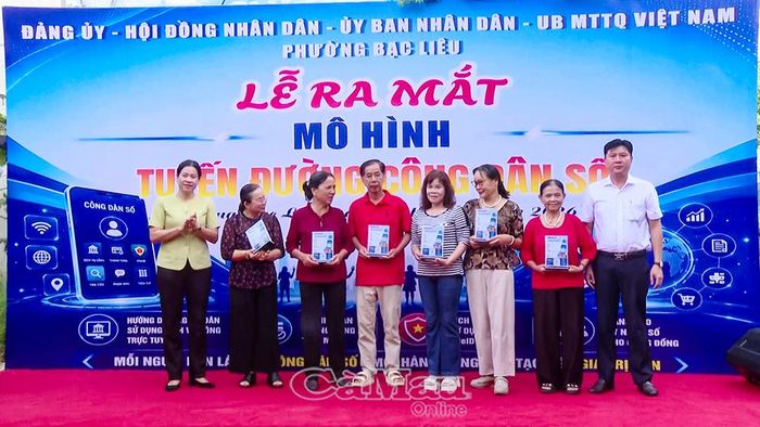 Bí thư Đảng ủy phường Bạc Liêu Tô Việt Thu (bìa trái) cùng Chủ tịch UBND phường Lê Việt Xô trao tặng bảng mã QR cho các hộ dân đại diện trên tuyến đường Bà Huyện Thanh Quan.