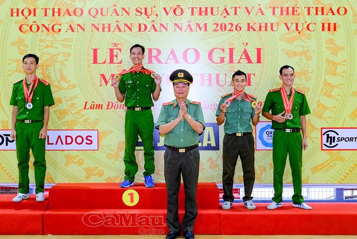  Thiếu tướng Lê Hồng Hiệp, Phó Cục trưởng Cục Công tác chính trị, Phó Trưởng ban Chỉ đạo Hội thao Bộ Công an, trao Huy chương Đồng cá nhân hạng cân dưới 60 kg cho đồng chí Danh Út Mười, cán bộ Công an xã Khánh An, tỉnh Cà Mau (bìa phải).