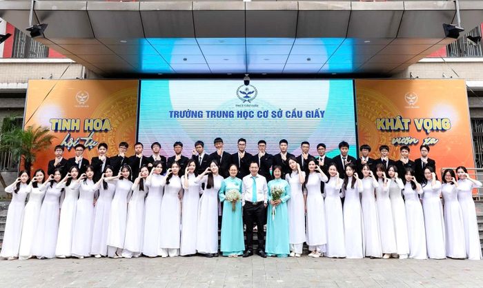 Tập thể lớp 9A5 Trường THCS Cầu Giấy chụp ảnh cùng Hiệu trưởng Lưu Văn Thông (giữa) và giáo viên chủ nhiệm Trần Thị Nga (áo xanh, bên trái).
