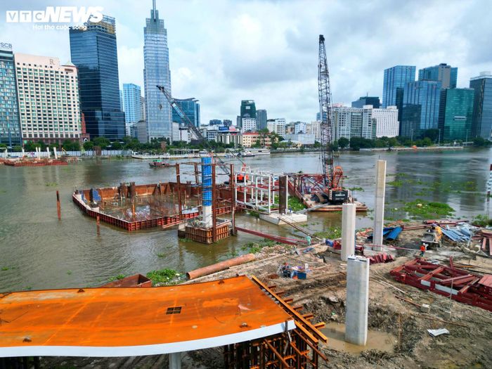 Trong đó, hạng mục cầu chính đã bước vào giai đoạn thi công tăng tốc với các phần việc như kết cấu mố, trụ bê tông, kết cấu vòm thép chính, trạm bơm, bể nước cảnh quan, cầu thang xoắn, thang cuốn, thang máy và hệ thống chiếu sáng mỹ thuật.