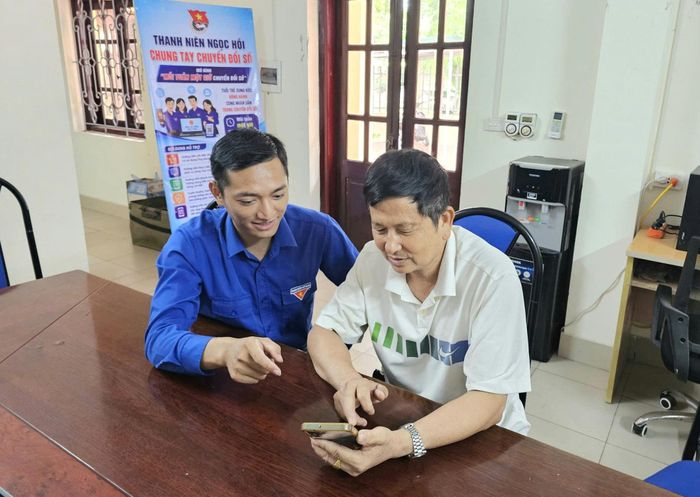 Thanh niên xã Ngọc Hồi hỗ trợ người dân tiếp cận chuyển đổi số. Ảnh: PV