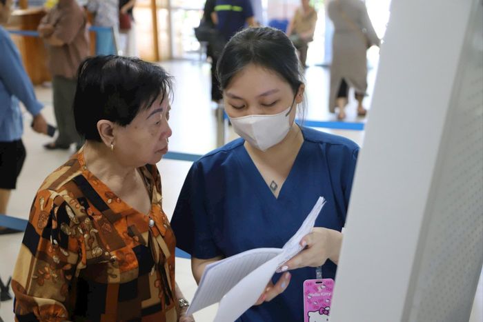Tận tình hướng dẫn người dân đi khám bệnh tại Bệnh viện Thanh Nhàn. Ảnh: BVCC
