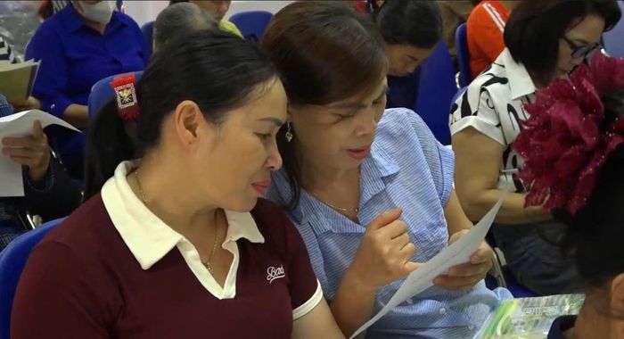Nhiều người dân được hướng dẫn cách đọc nhãn sản phẩm và truy xuất thông tin qua mã QR. Ảnh: Hồng Nhung