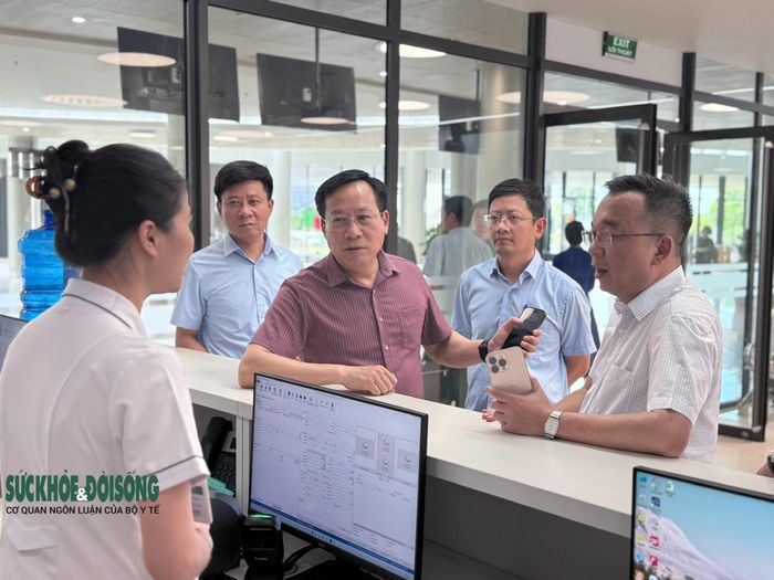 Thứ trưởng Bộ Y tế Lê Đức Luận nghe nhân viên y tế tại khu vực đón tiếp của Bệnh viện Bạch Mai báo cáo.
