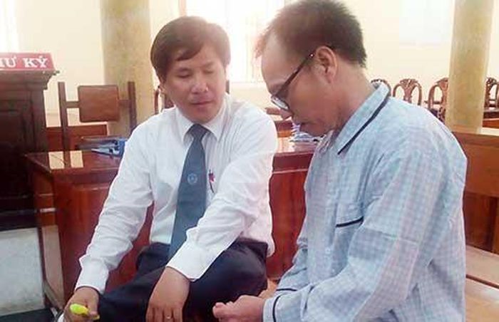 Ông Nguyễn Tấn Khoa (phải) đang trao đổi với luật sư Trần Cao Đại Kỳ Quân (người bào chữa cho ông) tại phiên tòa hồi tháng 5-2015. Ảnh: LỆ TRINH 