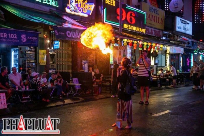  Dưới ánh đèn rực rỡ của phố Tây, những cột lửa liên tục bùng lên giữa tiếng nhạc sôi động. Phía sau các màn biểu diễn là câu chuyện mưu sinh và những dấu hỏi về công tác bảo vệ trẻ em. Ảnh: NHÓM PV 