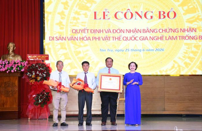  Lãnh đạo xã Tân Trụ đón nhận Bằng chứng nhận nghề làm trống Bình An được công nhận Di sản văn hóa phi vật thể quốc gia. Ảnh: HUỲNH DU 
