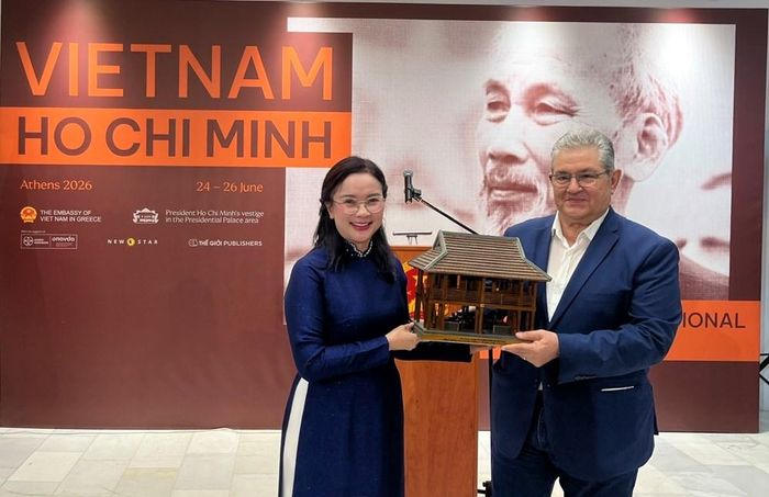 Giám đốc Khu Di tích Chủ tịch Hồ Chí Minh tại Phủ Chủ tịch Lê Thị Phượng trao tặng mô hình Nhà sàn Bác Hồ cho Tổng Bí thư Đảng Cộng sản Hy Lạp Dimitris Koutsoumpas