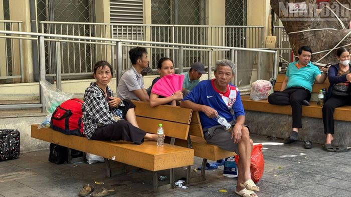Những gương mặt mệt mỏi của người nhà bệnh nhân ngồi chờ dưới cái nắng gay gắt của thủ đô Hà Nội.