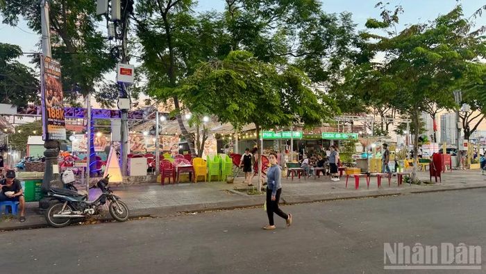 Những quán hàng hoạt động trên nền khu đất ngay đối diện cầu Rồng - một biểu tượng của thành phố.