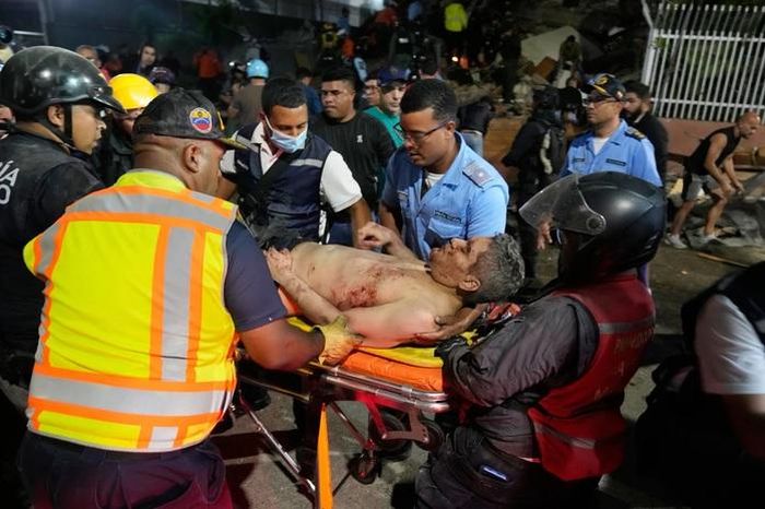 Nhân viên cứu hộ một người đàn ông bị thương sau trận động đất ở Caracas, Venezuela, ngày 24-6. Ảnh: AP