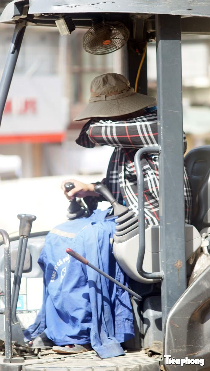 Anh liên tục gạt mồ hôi trên mặt. Bên trên đầu có một chiếc quạt nhỏ bằng bàn tay không thể làm giảm đi cái nắng nóng của mùa hè.