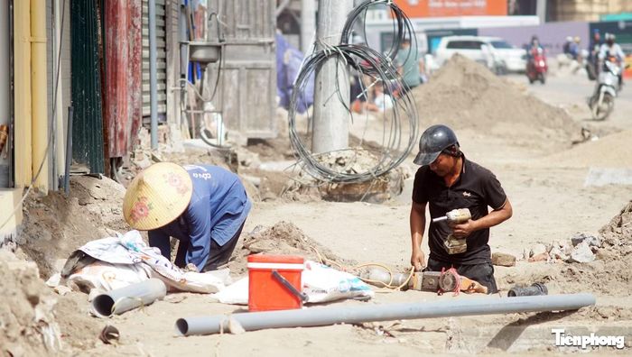 Công nhân thi công đường Vành đai 1 dưới nắng nóng gay gắt.