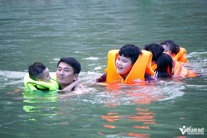 Các em nhỏ không biết bơi được mặc áo phao cẩn thận và có người lớn đi cùng. Ảnh: Lê Dương