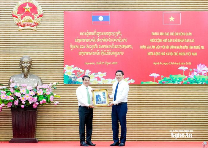 Bí thư Thành ủy, Chủ tịch HĐND Thủ đô Viêng Chăn Athsaphangthong Siphandone tặng quà lưu niệm đến Phó Bí thư Thường trực Tỉnh ủy, Chủ tịch HĐND tỉnh Nghệ An Hoàng Nghĩa Hiếu. Ảnh: Phạm Bằng