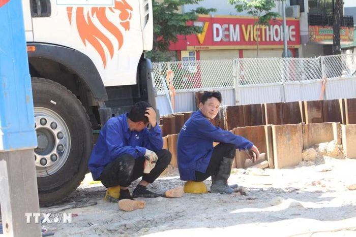 Công nhân tranh thủ nghỉ ngơi trong điều kiện thi công nắng nóng gay gắt trên đường Võ Chí Công. (Ảnh: Nguyễn Thắng/TTXVN)