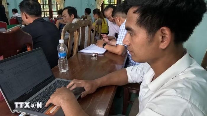Anh Hồ Trung Tơn, chuyên viên văn phòng UBND xã Trà Vân, tranh thủ xử lý các văn bản cần phát hành trong ngày bên lề lớp tập huấn AI. (Ảnh: Xuân Quý/TTXVN)