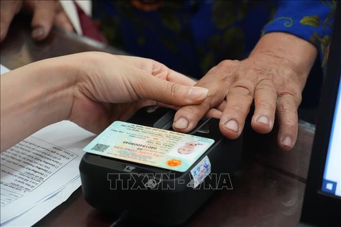 Lấy dấu vân tay của thân nhân liệt sĩ để xác định mẫu ADN. Ảnh: Bích Huệ/TTXVN