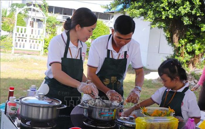 Đội thi chế biến món ăn tại hội thi nấu ăn với chủ đề “Bữa cơm gia đình gắn kết yêu thương”. Ảnh: Nguyễn Hằng/TTXVN