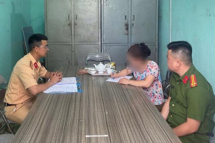 Người phụ nữ thản nhiên lắc vòng giữa đường ray tàu hỏa làm việc với lực lượng chức năng. Ảnh: Cục CSGT