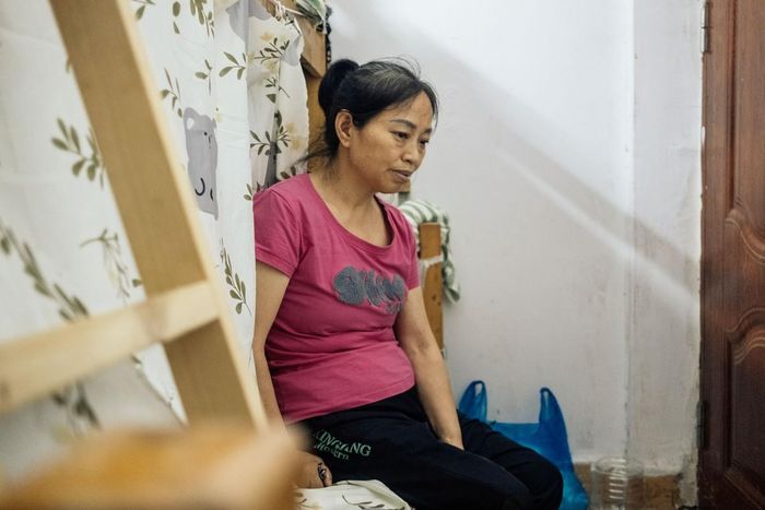 Bà Chen Chunfeng ngồi trên chiếc giường tầng dùng chung với một đồng nghiệp tại ký túc xá xưởng may ở Quảng Châu, tháng 5/2026. Ảnh: Wu Huiyuan/Sixth Tone.