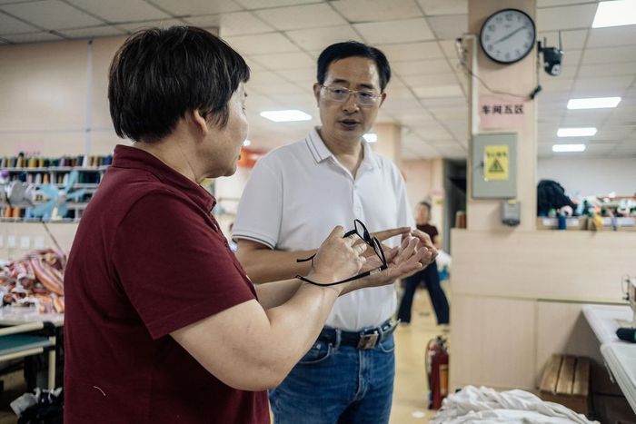 Ông Xie Qiang (phải) trao đổi công việc với quản lý xưởng may (trái) tại Quảng Châu, tháng 5/2026. Ảnh: Wu Huiyuan/Sixth Tone.