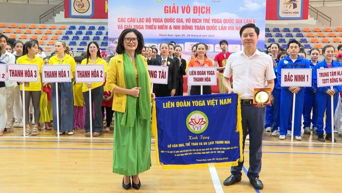 Đại diện lãnh đạo Liên đoàn Yoga Việt Nam tặng cờ và kỷ niệm chương cho Sở Văn hóa, Thể thao và Du lịch tỉnh Thanh Hóa - đơn vị phối hợp đăng cai tổ chức giải.