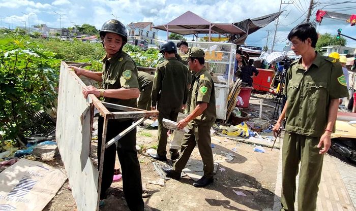 Lực lượng chức năng dọn dẹp vật dụng lấn chiếm vỉa hè, hành lang an toàn lộ giới.