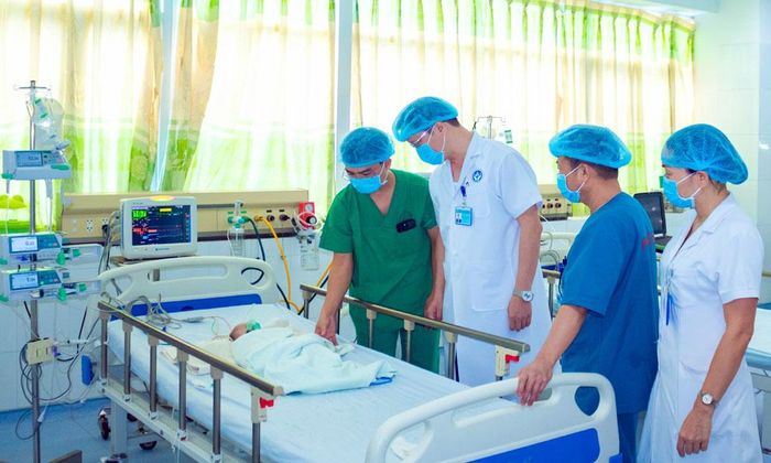 Bác sĩ Nguyễn Minh Cường (đứng ngoài cùng bên trái) kiểm tra quá trình phục hồi của bệnh nhi sau phẫu thuật. 