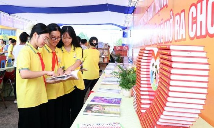  Các em học sinh đọc sách bên mô hình xếp sách nghệ thuật ấn tượng. 