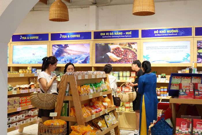 Du khách quốc tế lựa chọn các sản phẩm nông sản đặc trưng của thành phố làm quà tặng tại cửa hàng Đặc sản quà Đà Nẵng Vigift. Ảnh: H.A