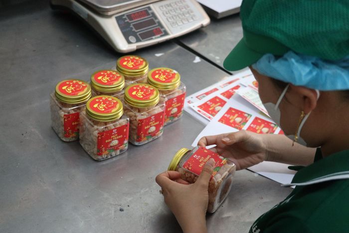 Công nhân dán nhãn bao bì sản phẩm tại Công ty TNHH Thực phẩm Mẹ Mít Hội An. Ảnh: H.Anh