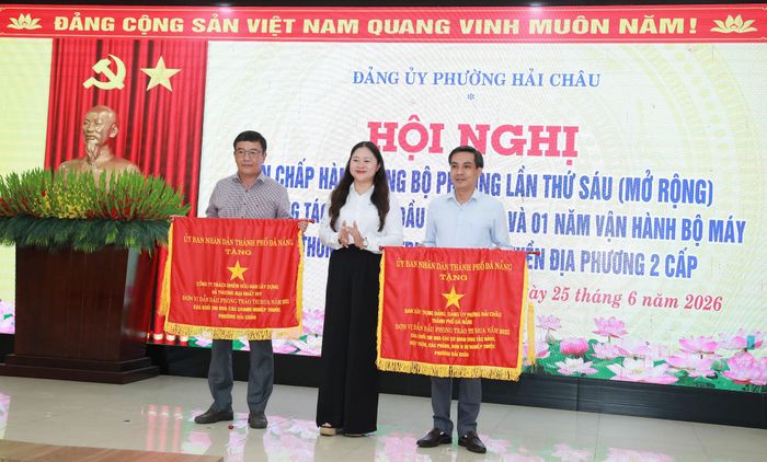 Bí thư Đảng ủy phường Hải Châu Cao Thị Huyền Trân trao Cờ thi đua của UBND thành phố cho 2 tập thể xuất sắc. Ảnh: ĐẮC MẠNH