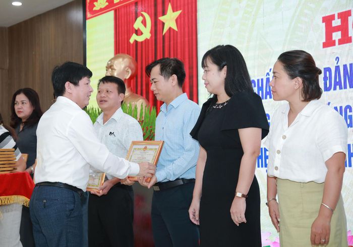 Chủ tịch UBND phường Hải Châu Nguyễn Văn Duy trao giấy khen cho các tập thể có thành tích xuất sắc trong sơ kết 1 năm thực hiện sắp xếp đơn vị hành chính các cấp và hoạt động của chính quyền địa phương 2 cấp. Ảnh: ĐẮC MẠNH