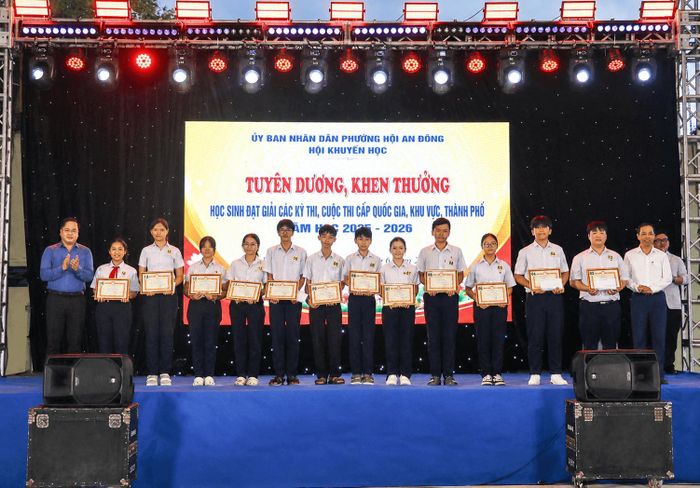 Lãnh đạo Sở Giáo dục và Đào tạo (ngoài cùng bên trái) và lãnh đạo phường Hội An Đông trao thưởng cho các học sinh có thành tích xuất sắc tại các kỳ thi khu vực, thành phố. Ảnh: QUỐC TUẤN