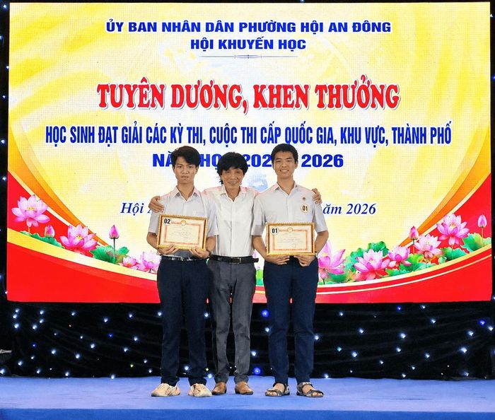 Ông Nguyễn Sự, nguyên Bí thư Thành ủy Hội An (cũ) trao thưởng cho 2 học sinh đoạt giải tại kỳ thi học sinh giỏi cấp quốc gia. Ảnh: QUỐC TUẤN