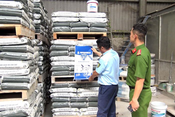 Cán bộ cơ quan chức năng đối chiếu mẫu mã hàng hóa có dấu hiệu vi phạm. Ảnh: Quốc Vinh