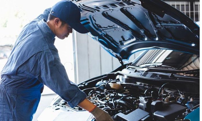 Kỹ sư ô tô hiện đại làm việc với các thiết bị chẩn đoán công nghệ cao và hệ thống vi mạch phức tạp.