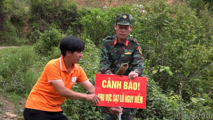 Anh Giàng A Khổng, Bí thư chi bộ thôn Háng Tày, xã Trạm Tấu cùng cán bộ Ban Chỉ huy Quân sự xã cắm biển cảnh báo tại các điểm xung yếu.