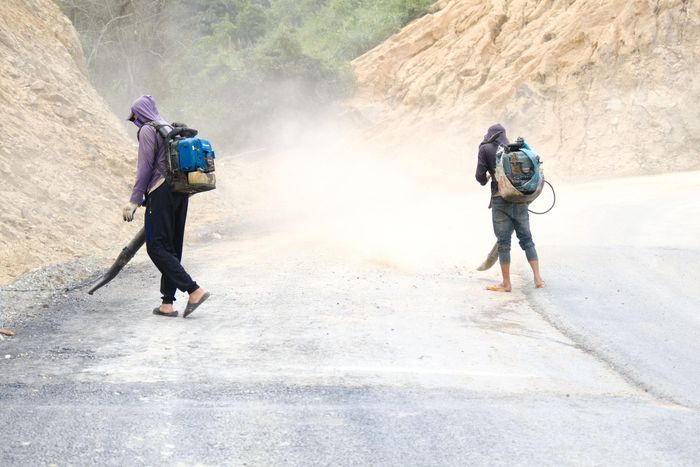 Công nhân đơn vị thi công thực hiện thổi bụi để chuẩn bị thảm nhựa 300 m đường cuối cùng của công trình