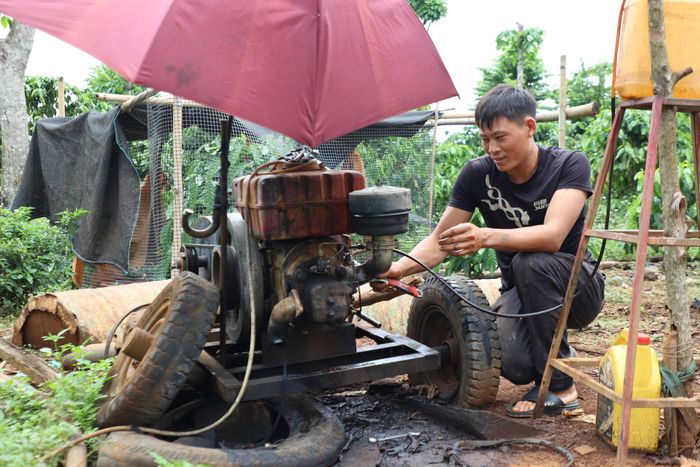 Anh Lý Văn Tiến sửa lại chiếc máy nổ để lấy nước sinh hoạt cho cả cụm dân cư