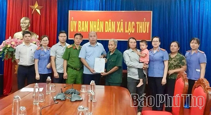 Lãnh đạo UBND xã Lạc Thủy trao giấy khai sinh cho gia đình cháu Bùi Thanh Hoa.