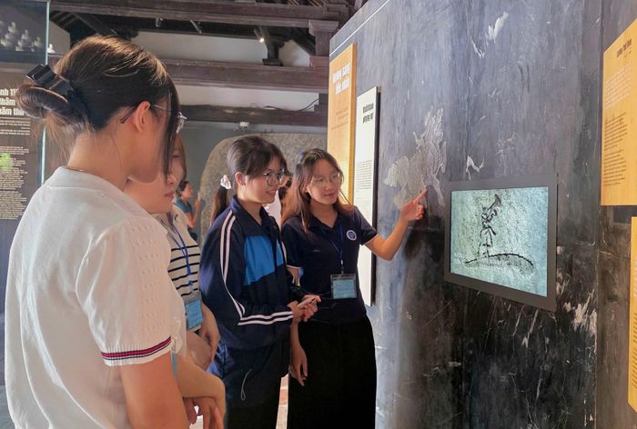 Khách tham quan tìm hiểu các hình thức tôn vinh tân khoa thông qua công nghệ trình chiếu tại khu trưng bày “Sử đá lưu danh” ở Văn Miếu - Quốc Tử Giám. (Ảnh: BTC).