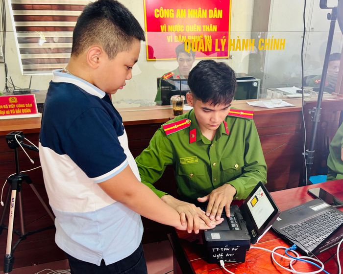 Cán bộ công an xã Kim Bảng hướng dẫn học sinh thu nhận dấu vân tay khi làm căn cước