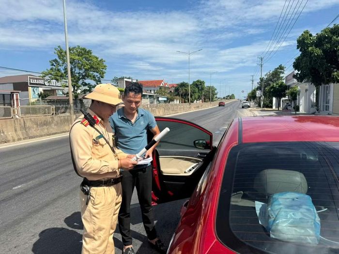 Cảnh sát Giao thông Công an tỉnh Quảng Trị kiểm tra giấy tờ xe đối với một chủ phương tiện.